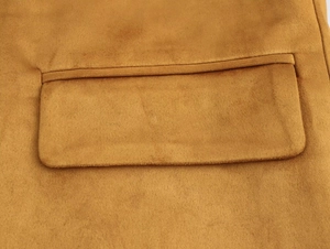 Detailed view of the ginger yellow faux suede blazer with a clean flap pocket and neat stitching