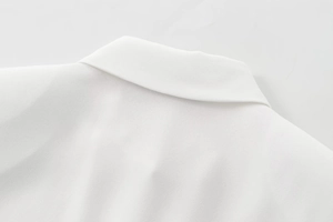 Close-up of lapel collar and matte texture fabric on white long sleeve blouse