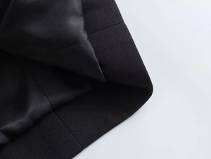 Detailed close-up of woven fabric texture and smooth black satin lining on the jacket