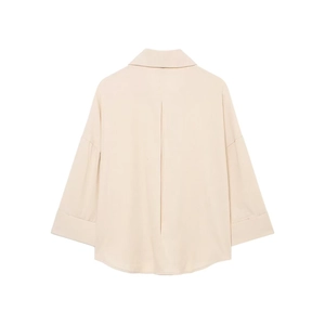 Vista posteriore di una camicia beige oversize con piega a baciata e orlo curvo