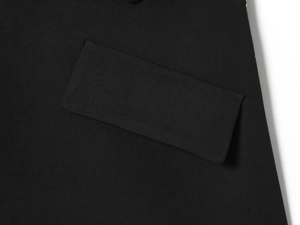 Detailed close-up of the flap pocket and stitching on a black blazer mini dress