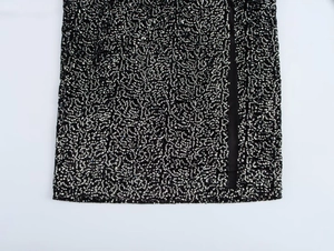 Detail shot of the sequin hem on this black asymmetric dress with silver sparkles