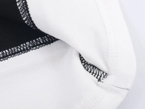 Gros plan des coutures contrastées et des ourlets renforcés sur tricot double couche