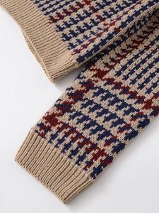 Dettaglio di maglione in maglia con motivo pied-de-poule tricolore e polsini a costine