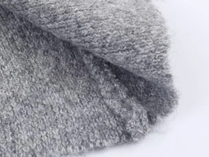 Close-up of soft grey gradient knit fabric with a plush mohair texture and thick weave