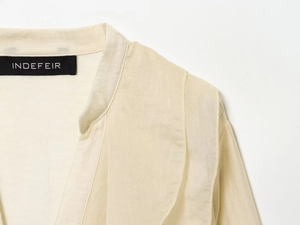 Detail view of the ruffle neck chiffon shirt with woven label and fine fabric texture
