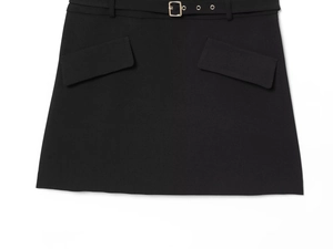 Detail of a black A-line mini skirt featuring a thin belt with a gold square buckle