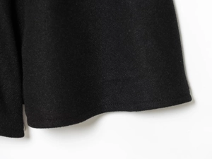 Detail of premium black wool blend fabric showing thick texture and clean hem stitching