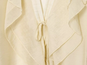Close-up of elegant ruffled V-neckline with adjustable tie on beige linen blouse