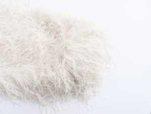 Gros plan sur la texture des plumes blanches et la fourrure synthétique de la veste