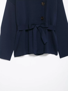 Detail view of navy blue knit cardigan with brown buttons and an elegant waist tie belt