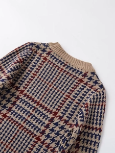 Dettaglio della trama in maglia pied de poule e dello scollo a coste del maglione