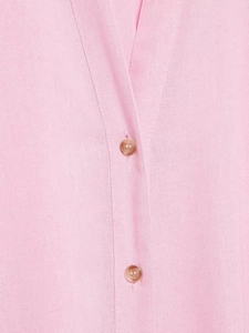 Dettaglio della maglia rosa con texture fine e bottoni marroni sulla scollatura a V