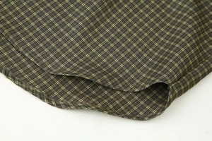 Close-up of deep olive plaid fabric showing fine stitching and cotton blend texture