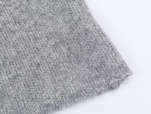 Close-up of gray knitted fabric texture showing premium stitching and soft fiber details