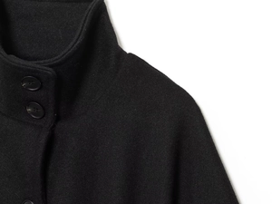 Detailed close-up of high-quality black wool coat with stand-up collar and round buttons