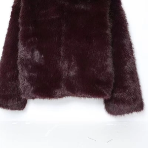 Gros plan détaillé montrant la texture douce en fausse fourrure bordeaux de cette veste