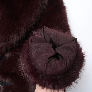 Gros plan du poignet d'un manteau en fausse fourrure bordeaux avec doublure soyeuse