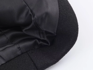 Detailed macro view of black wool blend coat fabric with smooth satin lining texture