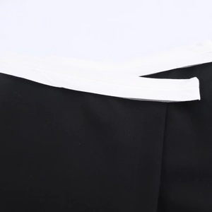 Detail of contrast waist design with black fabric and white wrap-around crisscross ties
