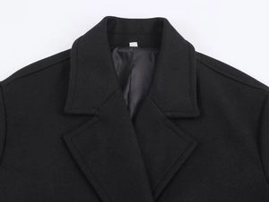 Detail of wool blend coat showing wide lapel collar and high-quality fabric texture
