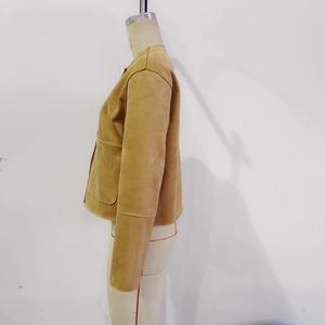 Detail view of camel faux suede jacket featuring a collarless design and large front pockets
