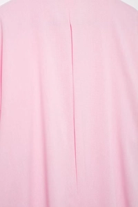 Dettaglio del tessuto rosa intrecciato e della cucitura a pieghe sul retro della camicia