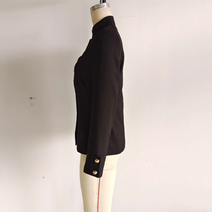 Close-up of black stand collar blazer showing gold buttons and fine twill fabric texture