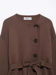 Close-up of brown knit cardigan with large buttons and matching tie belt detail