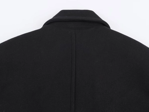 Detail shot of the back collar and wool blend texture of a black oversized coat