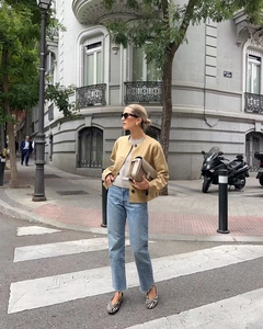 Outdoor street style view of camel suede bomber jacket with grey knitwear and jeans