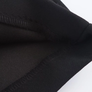 Close-up of precise stitching and reinforced overlock seams on black skort fabric