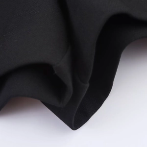 Detailed macro view showing the high-quality black knit fabric texture and neat piped edges