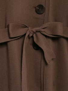 Detail of a brown knit cardigan featuring a waist tie bow and tortoiseshell buttons