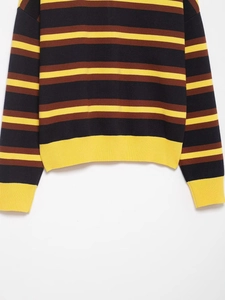 Detail of striped knit sweater showing navy and yellow ribbed cuffs and hem textures