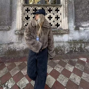 Nahaufnahme einer braunen Kunstpelzjacke mit breitem Kragen und dichter Textur im Freien