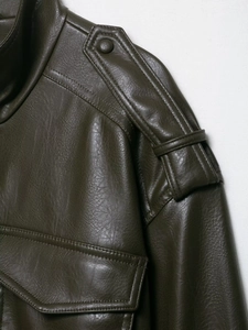 Gros plan sur la veste en similicuir olive montrant les épaulettes et les coutures