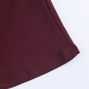 Detailed macro view of burgundy twill fabric with precise double-needle hemmed stitching