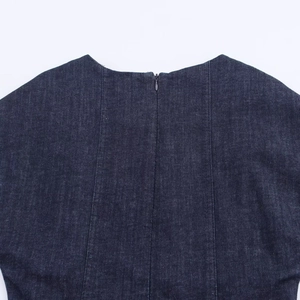 Détail du dos d'une robe en jean bleu foncé avec fermeture éclair invisible et coutures