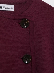 Close-up of wine red knitted jacket with tortoiseshell buttons and brand label
