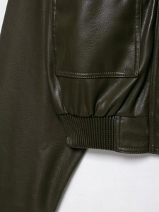 Détail d'une veste en simili cuir olive avec ourlet côtelé et grande poche plaquée latérale