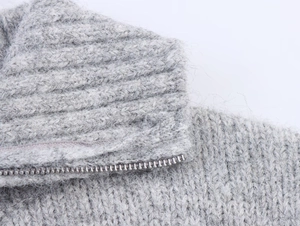 Detail of grey knitted sweater showing fuzzy wool texture and silver metal half-zipper