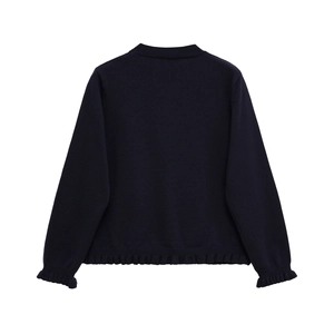 Détail de l'ourlet et des poignets à volants sur le pull en maille bleu marine