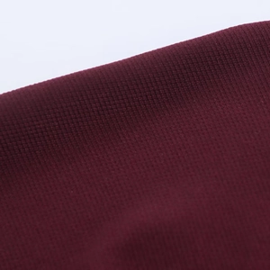 Macro shot of elegant burgundy pleated knit fabric texture and breathable mesh detail