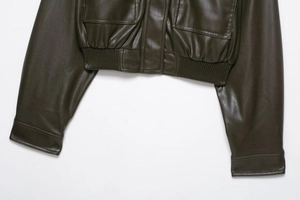 Vue détaillée du blouson en similicuir vert olive foncé avec ourlet côtelé et poches à rabat
