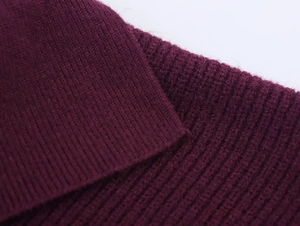 Macro detail of dark burgundy core yarn knit fabric showing fine ribbed texture and seams