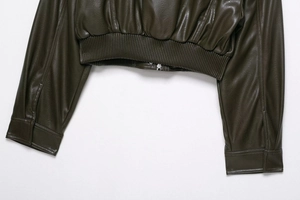 Détail de la veste en similicuir vert olive avec ourlet côtelé et fermeture éclair argentée