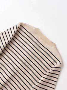 Détail du pull en maille rayé beige avec col rond côtelé et texture délicate