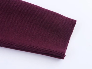 Macro close-up of dark purple ribbed knit fabric texture on batwing sleeve sweater