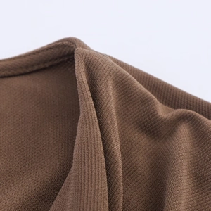 Close-up of brown knit dress showing detailed ribbed texture and fine stitching quality